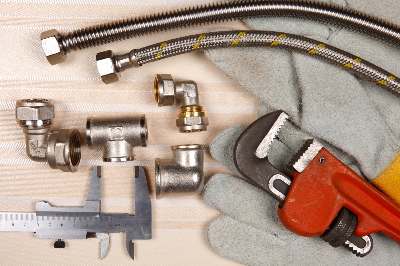 Plumber working on pipes in a Longfield home